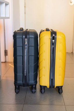 İki şık bavul, biri koyu yeşil ve biri sarı, yan yana oturup seyahate hazır olmayı sembolize ediyor. Tatil planlama ya da iş gezileri için mükemmel, turizm illüstrasyonu için ideal.