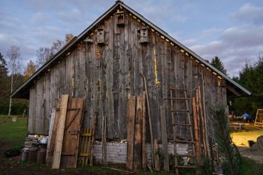 Bu ahşap ahır kuş evleri ve merdivenleri sergiliyor, kırsal çekiciliği somutlaştırıyor. Yıpranmış odunları ve sakin kırsal kesimi, ülkenin yaşam temaları için ideal huzurlu bir manzara yaratıyor..