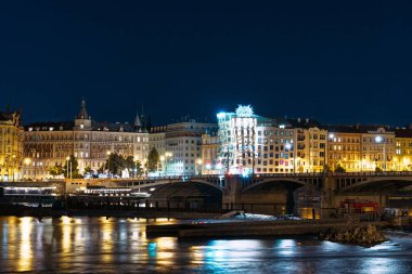 Geceleri Prag 'ın büyüleyici güzelliğini keşfedin. Aydınlatılmış ufuk çizgisi ve Vltava Nehri nefes kesici bir şehir manzarası yaratıyor, seyahat meraklıları için mükemmel. Prag Konumu.