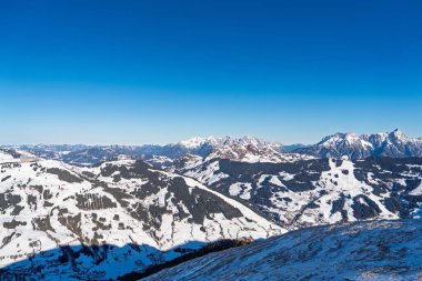 Avusturya Alpleri, Kaprun 'da, açık mavi gökyüzünün altındaki karla kaplı dağ tepelerinin çarpıcı manzarası. Avusturya Alpleri, Kaprun 'da kayak ve turizm tanıtımı için mükemmel bir kış manzarası..