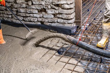 İnşaat işçisi beton döşeyerek beton döker. Bu süreç, binaların ve yenileme projelerinin sağlamlığı ve istikrarının sağlanması açısından hayati önem taşıyor..