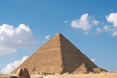 Büyük Giza Piramidi 'nin çarpıcı manzarası, antik Mısır' ın mimari dehasını gözler önüne seriyor. Açık mavi gökyüzüne karşı bu ikonik anıtın tarihini ve ihtişamını tecrübe edin..