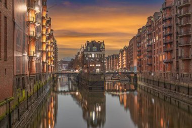 Dramatik alacakaranlık, Almanya 'nın UNESCO' nun Dünya Mirası adlı tarihi Speicherstadt sahası Hamburg 'u aydınlattı. Antik binalar kanallara yansıyor, alacakaranlıkta çarpıcı bir mimari sergiliyor.