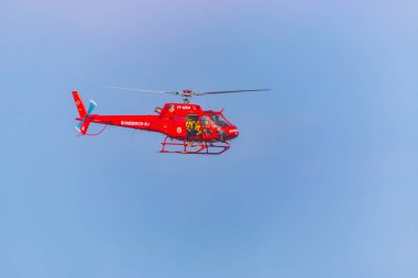Rio de Janeiro, Brezilya 'daki itfaiye birliğinin kırmızı helikopteri - 6 Eylül 2020: Rio de Janeiro. Rio de Janeiro itfaiyecilerinin helikopteri Copacabana plajında kurtarma operasyonundan önce uçuyor..