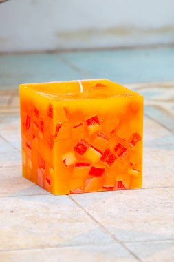 Yerdeki mermer parçasının üzerinde portakal aromalı mum..