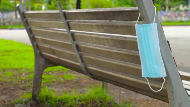 青い使い捨ての保護マスクは コルナウイルスから保護するために使用され リオデジャネイロの木製のベンチに投げられました — ストック動画