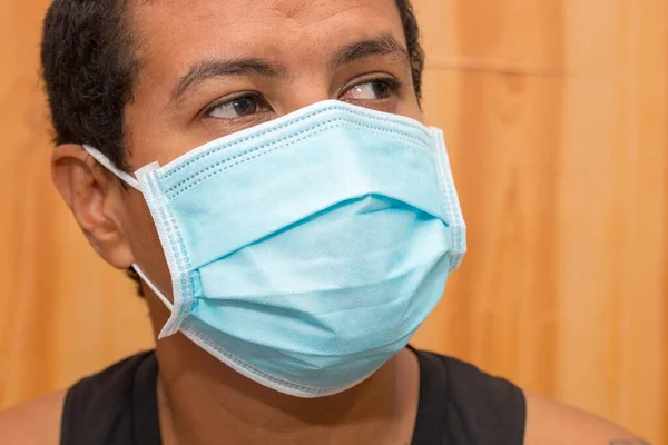 Black man with blue protective mask against coronavirus in rio de janeiro brazil.