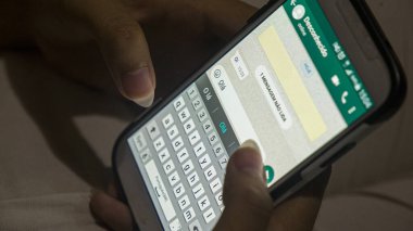 Kadın elleri Rio de Janeiro 'daki beyaz bir cep telefonundan Portekizce mesaj yazıyor..