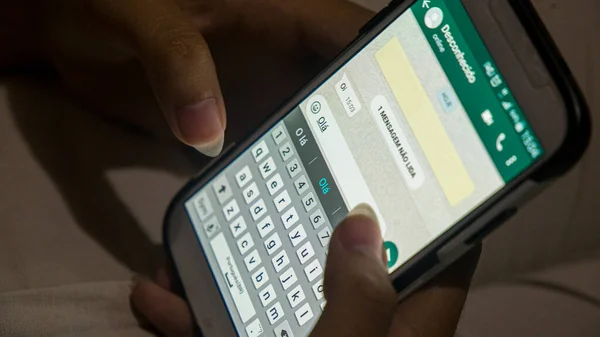 Kadın elleri Rio de Janeiro 'daki beyaz bir cep telefonundan Portekizce mesaj yazıyor..