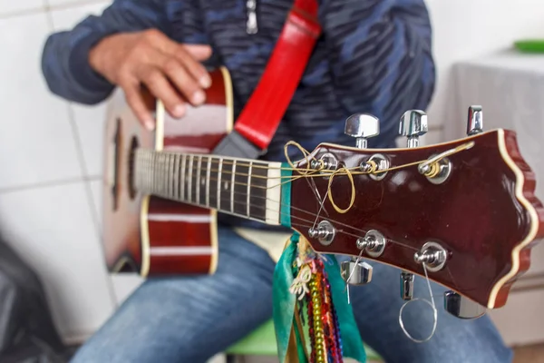 old man with guitar in hand, before playing a song of revelry of kings.