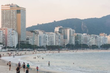 Rio de Janeiro, Brezilya 'daki Copacabana Plajı' nda öğleden sonra - 27 Mart 2021: Rio de Janeiro 'daki Copacabana Plajı' nda eğlenen insanlar.