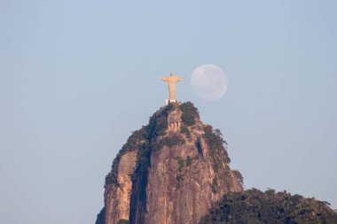 Rio de Janeiro, Brezilya 'da Kurtarıcı İsa' nın yanında ay batarken - 24 Ağustos 2021: Rio de Janeiro 'daki Kurtarıcı İsa heykelinin yanında ay batarken.