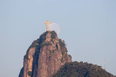 Rio de Janeiro, Brezilya 'da Kurtarıcı İsa' nın yanında ay batarken - 24 Ağustos 2021: Rio de Janeiro 'daki Kurtarıcı İsa heykelinin yanında ay batarken.