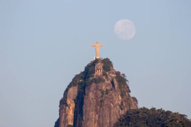 Rio de Janeiro, Brezilya 'da Kurtarıcı İsa' nın yanında ay batarken - 24 Ağustos 2021: Rio de Janeiro 'daki Kurtarıcı İsa heykelinin yanında ay batarken.