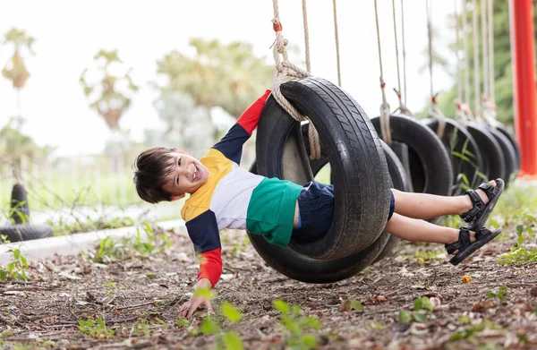 Niño Con Ropa Colores Brillantes Jugando Swing Neumático Colgando Patio — Foto de Stock