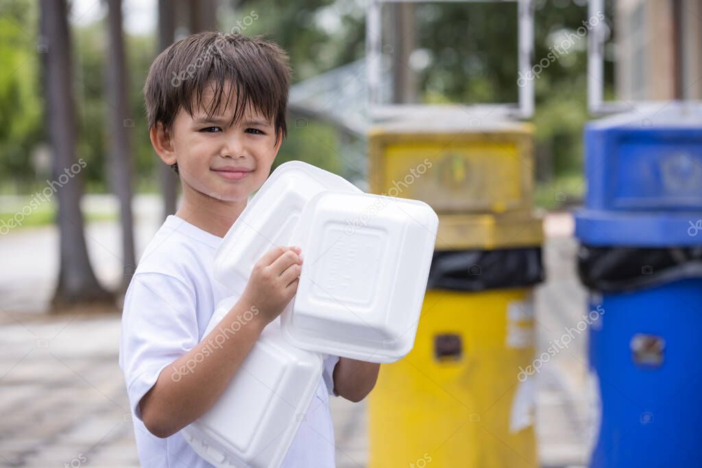 A boy keeping the styrofoam box to put in the trash.Styrofoam boxes for take-out food at home cause pollution and cannot be reused.