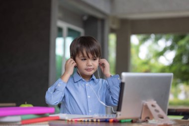 Ödevi için tablet kullanan çocuk izolasyonu, internetteki dijital tablet arama bilgilerini kullanarak covid 19 tecrit, evde eğitim, sosyal mesafe, E-öğrenim çevrimiçi eğitim