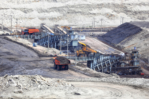 heavy construction tipper trucks dump coal to the conveyor at co