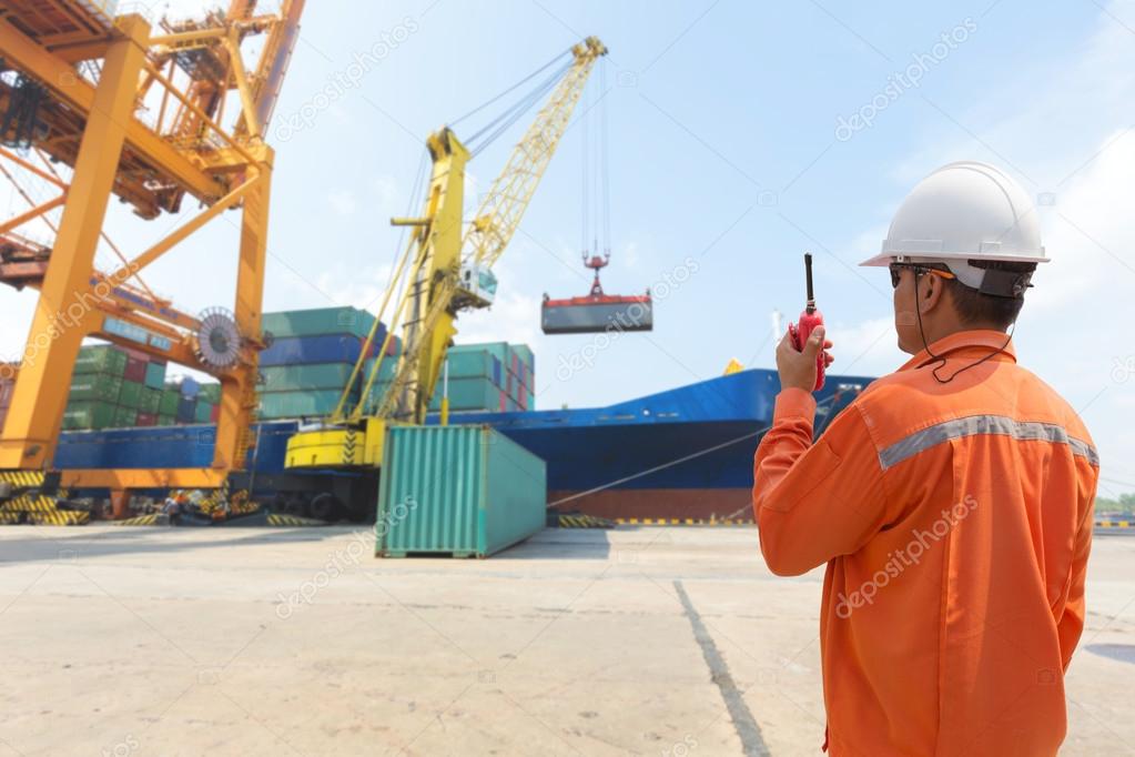 foreman control loading Containers box from Cargo freight ship