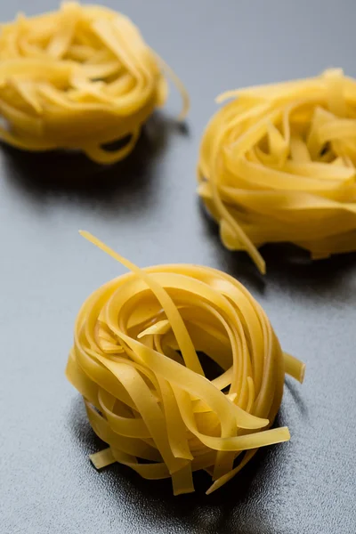 Tagliatelle na mesa preta — Fotografia de Stock