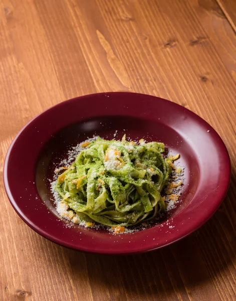 Tagliatelle dish in red plate — Stock Photo, Image