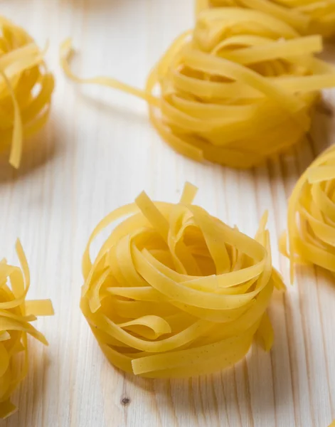 Tagliatelle pasta on wooden table — Stock Photo, Image