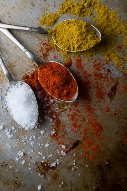 tuz, kırmızı biber ve köri çelik kaşık üzerinde
