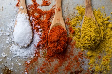 tuz, kırmızı biber ve köri tahta kaşıklar üzerinde