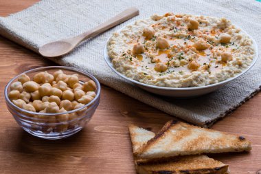 ahşap masa üzerinde ev yapımı humus