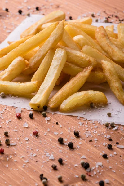 Patatine fritte su un tavolo di legno con condimento — Foto Stock