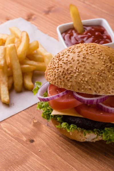Homemade hamburger on wooden table with fries — Stock Photo, Image