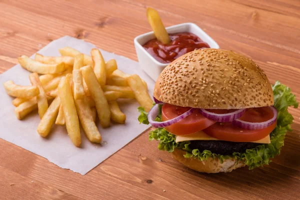 Homemade hamburger on wooden table with fries — Stock Photo, Image