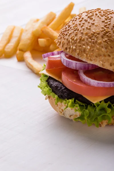 Hamburger on white table with fries — Stock Photo, Image