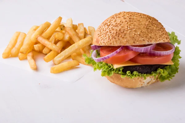 Hamburger on white table with fries — Stock Photo, Image