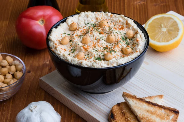 Hummus in black bowl — Stock Photo, Image