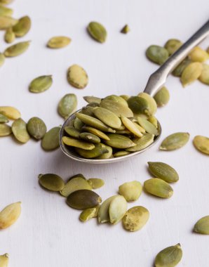 kaşık ile beyaz tabloda kabak çekirdeği