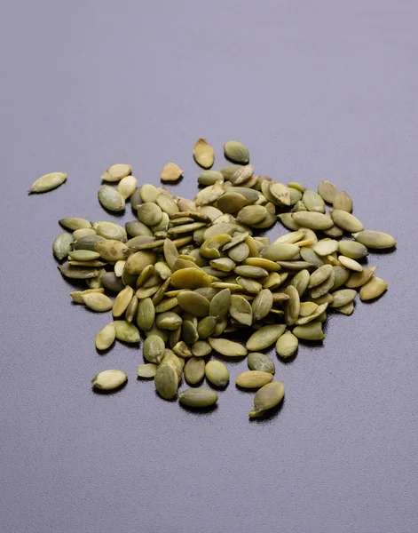 Pumpkin seeds on black table — Stock Photo, Image