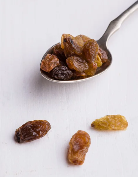 Raisins on steel spoon — Stock Photo, Image