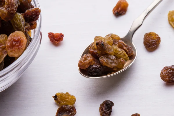 Raisins on steel spoon — Stock Photo, Image