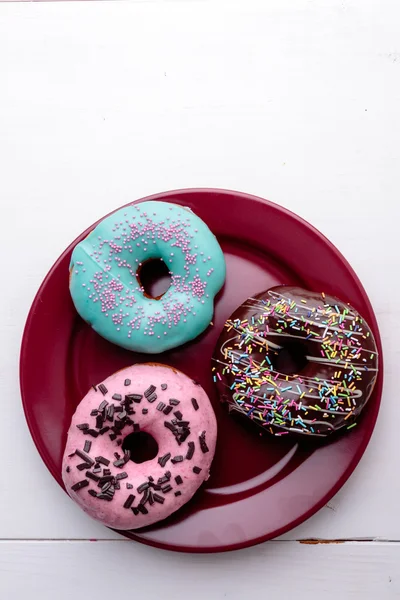 Donuts na placa vermelha — Fotografia de Stock