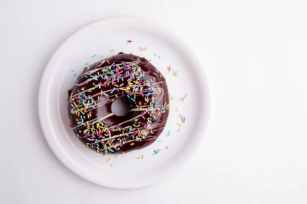 Donut de chocolate com polvilhas — Fotografia de Stock