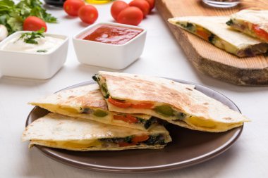 Quesadilla dilimleri kahverengi plaka üzerinde
