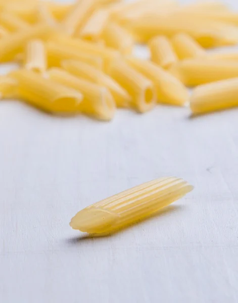 Raw penne on table — Stock Photo, Image