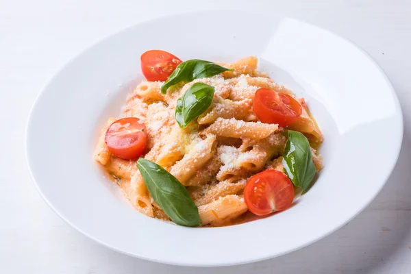 Penne con tomate en plato blanco — Foto de Stock