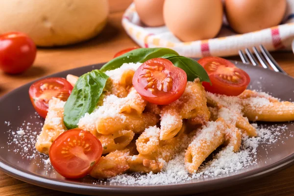 Penne with tomato in brown plate — Stock Photo, Image