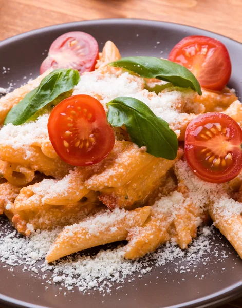 Penne con tomate en plato marrón — Foto de Stock