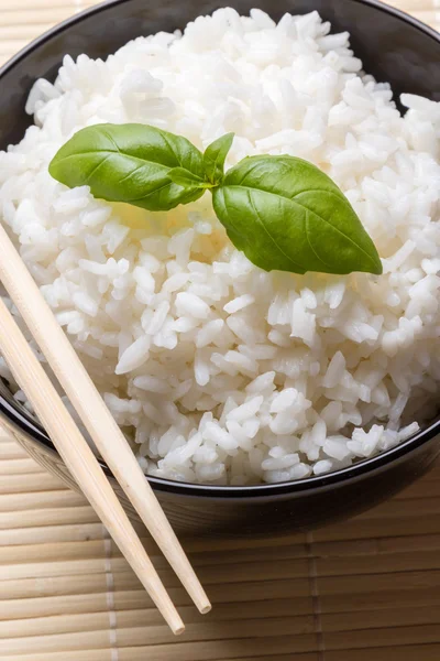 Варёный рис в чёрной миске — стоковое фото
