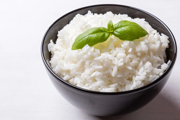 Варёный рис в чёрной миске — стоковое фото