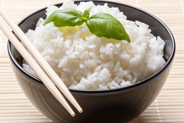 Cooked rice in black bowl — Stock Photo, Image