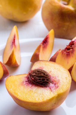 Şeftali beyaz tabakta kesmek